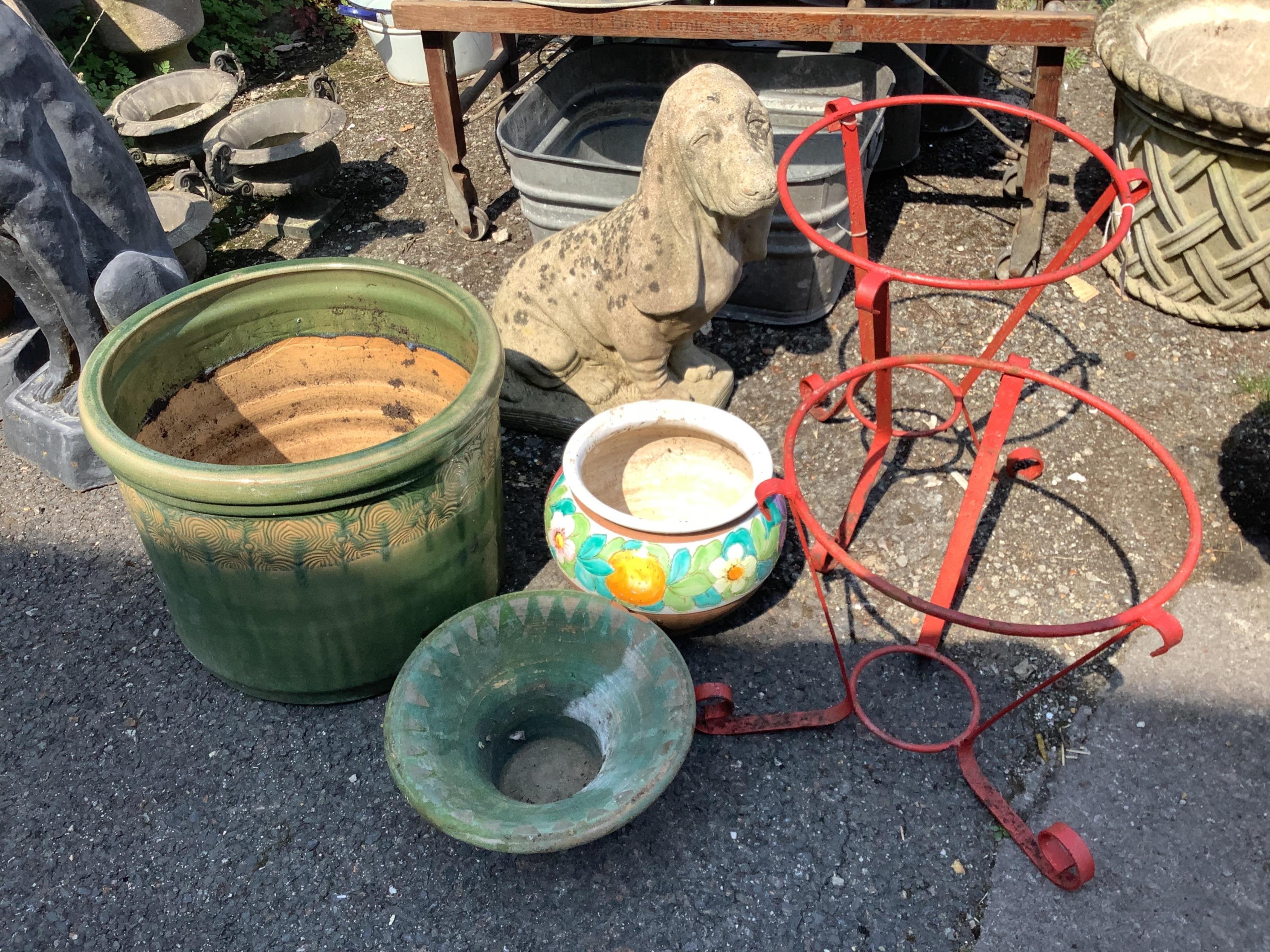 A reconstituted stone seated Basset hound garden ornament, height 52cm, three glazed earthenware planters and a pair of wrought iron pot stands. Condition - fair